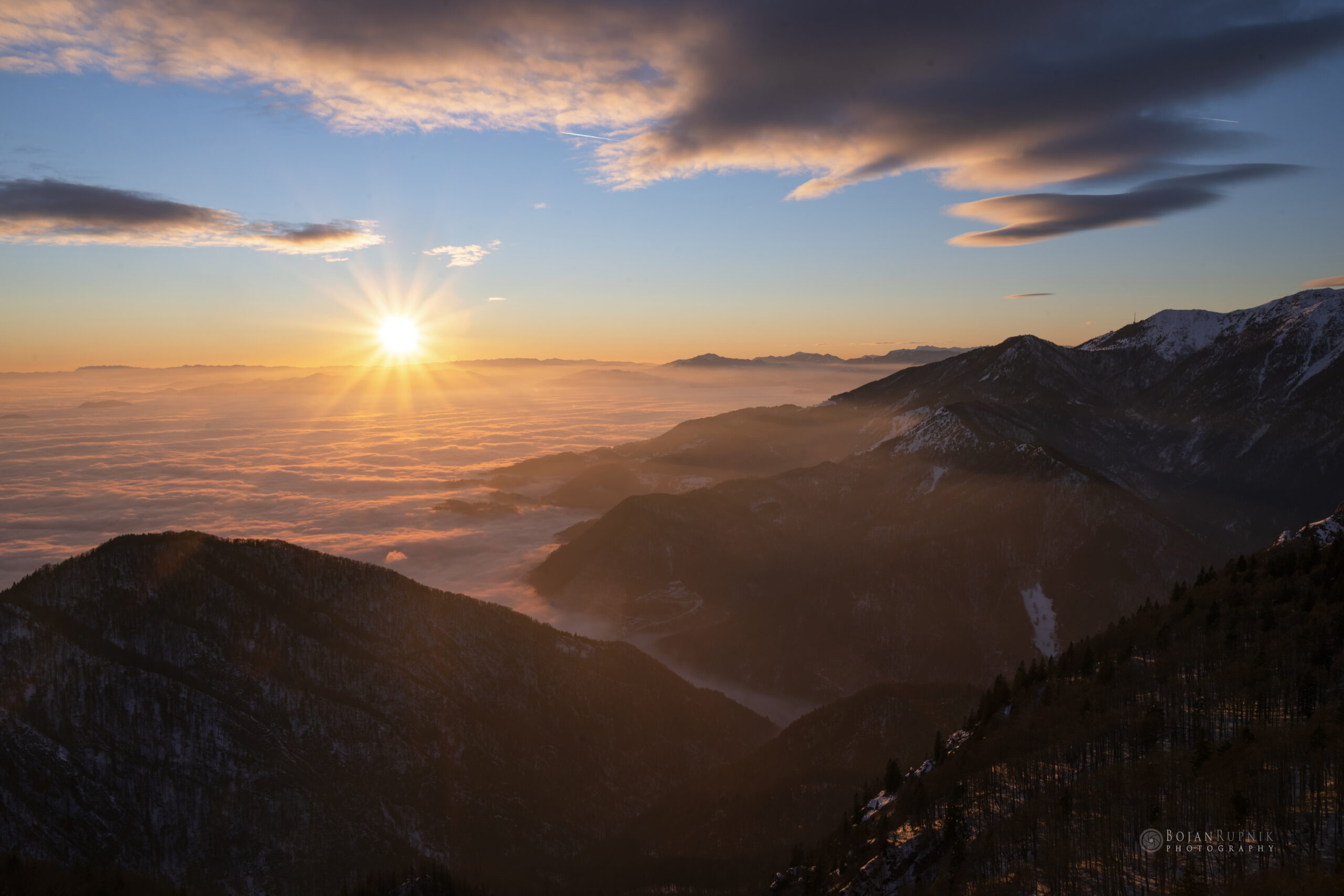 Sončni zahod na Veliki Planini z oblaki nad dolino