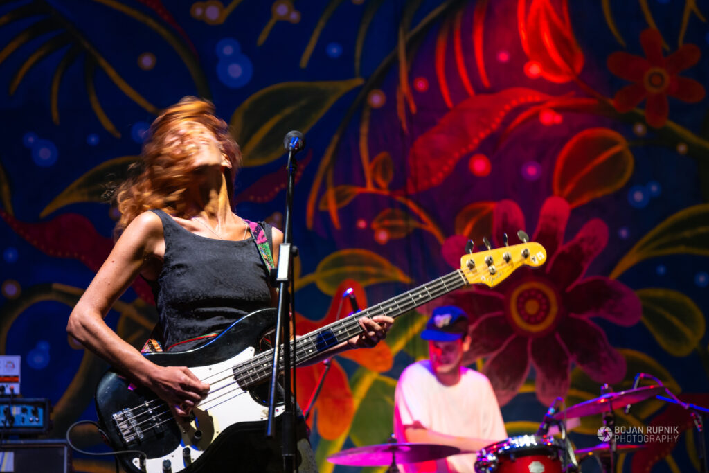 Kitaristka in bobnar v ozadju